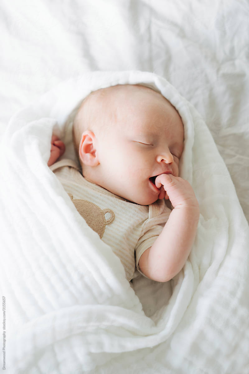 Tiny newborn infant sleeping on blanket