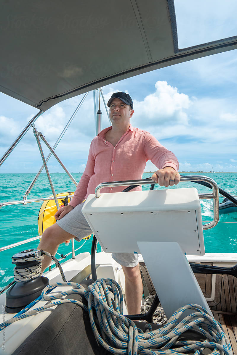 Skipper at Helm of Luxury Cruising Sailboat on Caribbean Island