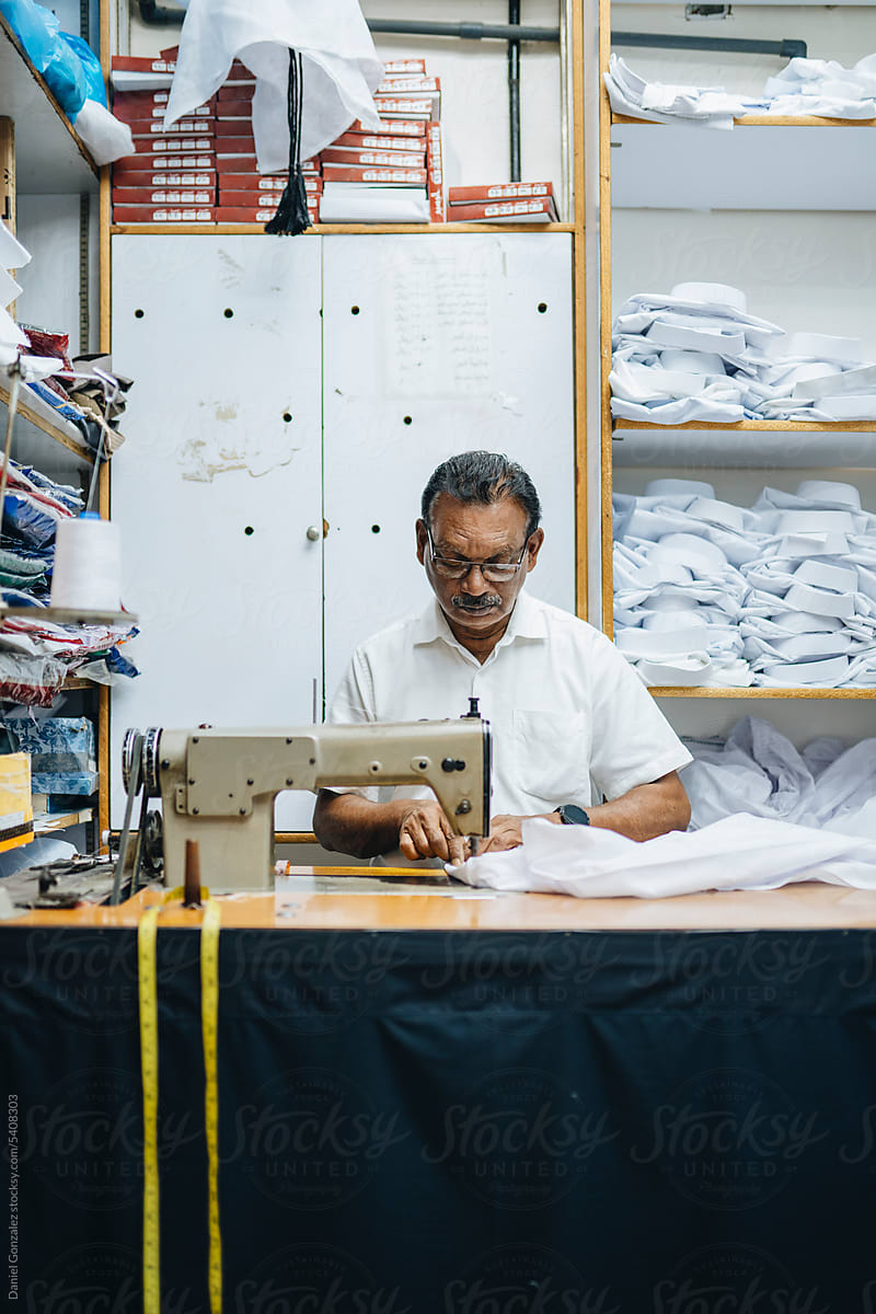 Concentrated Indian tailor using sewing machine