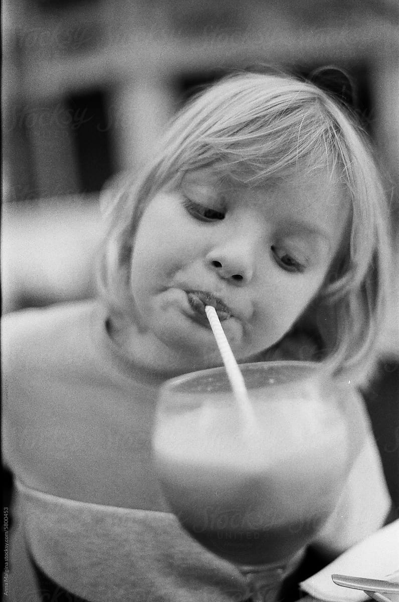 A blond kid drinking a milkshake