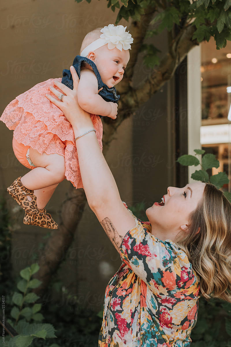 Young Mom Lifting Baby Girl in Air
