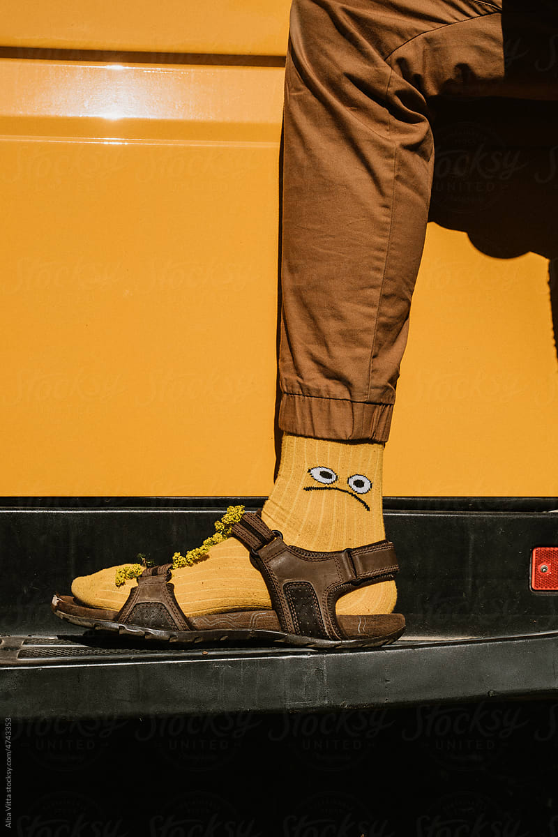 Man wearing socks with sandals with flowers at camper van