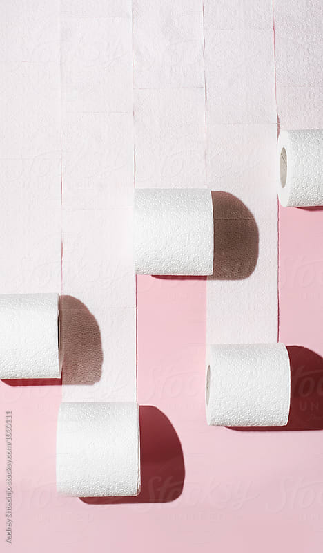 Toilet paper rolls on pink background.