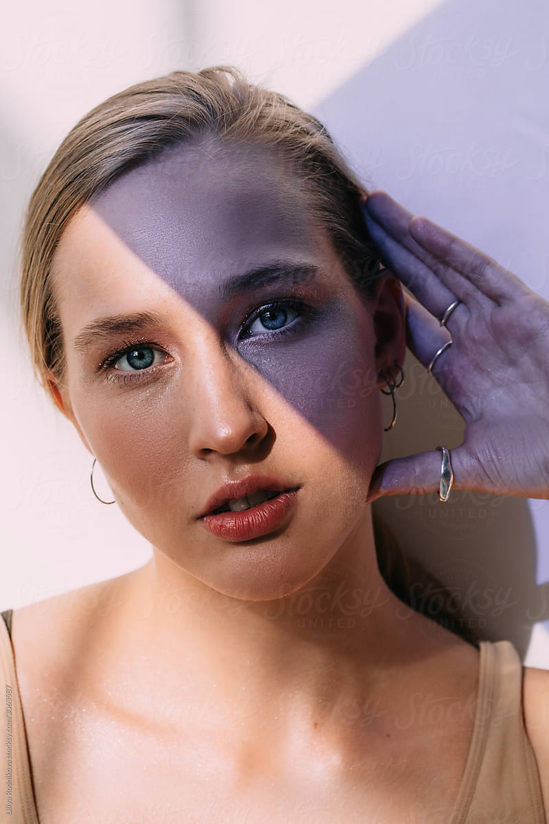 Beauty portrait with half-face in blue shadow