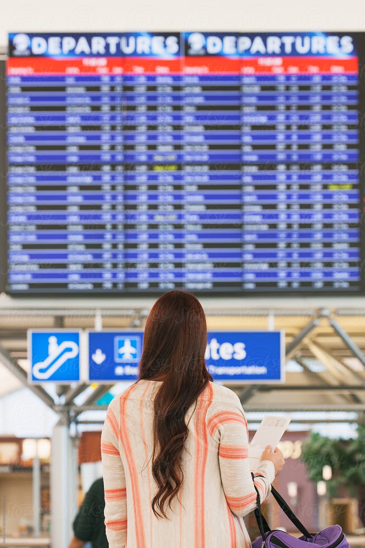 Airport: Woman Reading Flight Departure Board