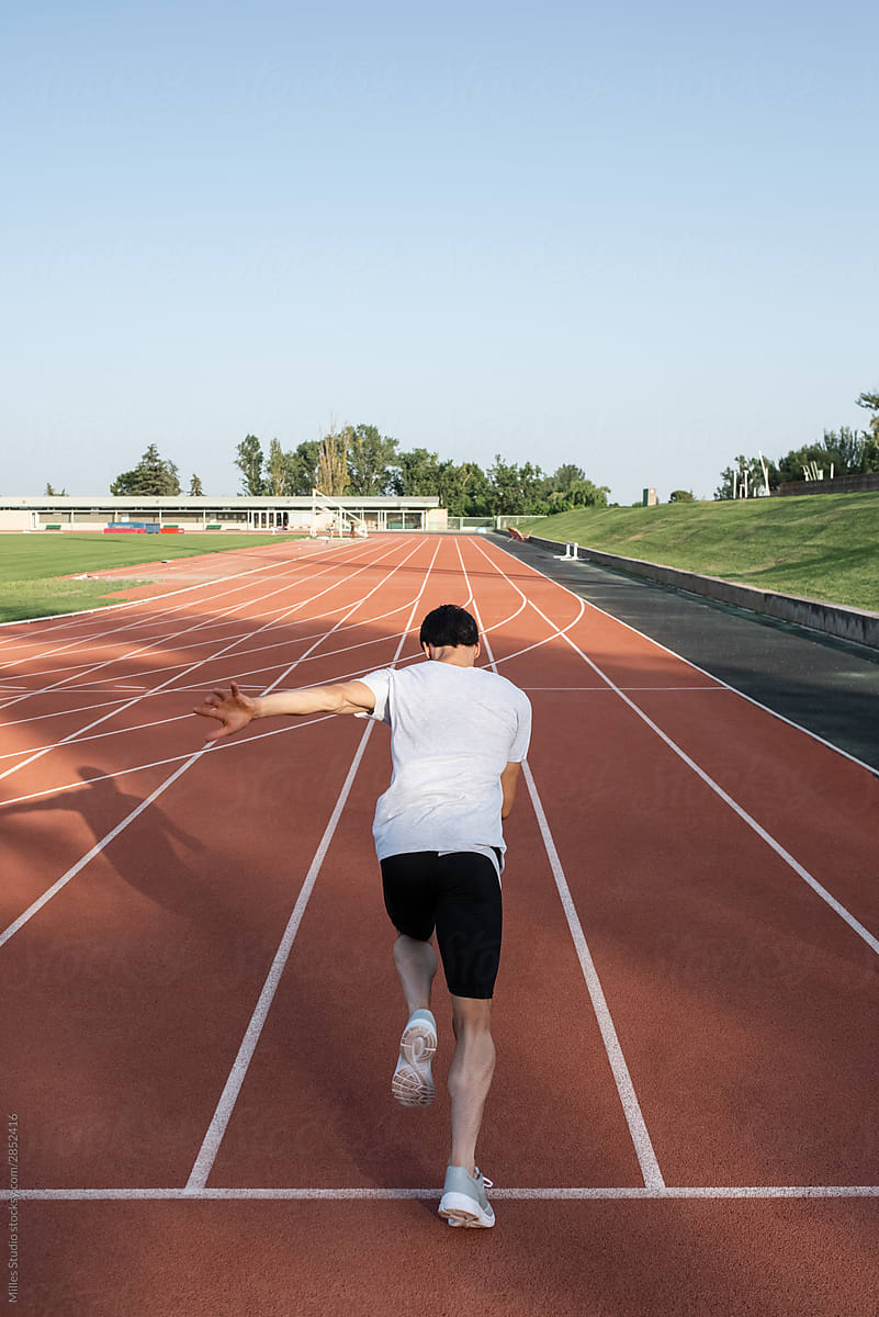 Unrecognizable sportsman sprinting on track
