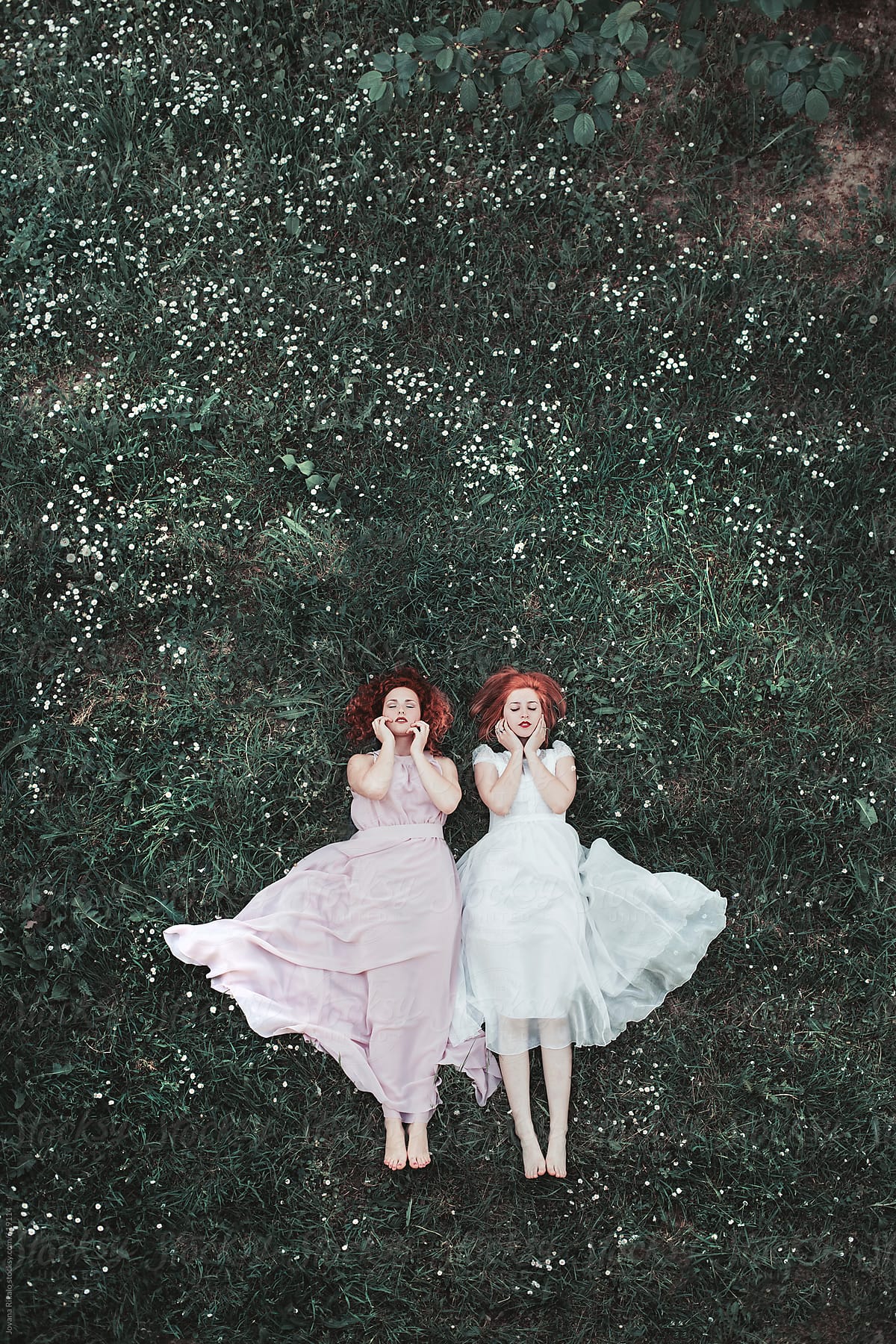 Two Ginger Female Friends Laying On The Grass In A Long Dresses By Stocksy Contributor Jovana