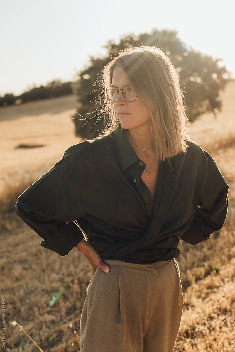 Portrait of a woman standing on a field during sunset