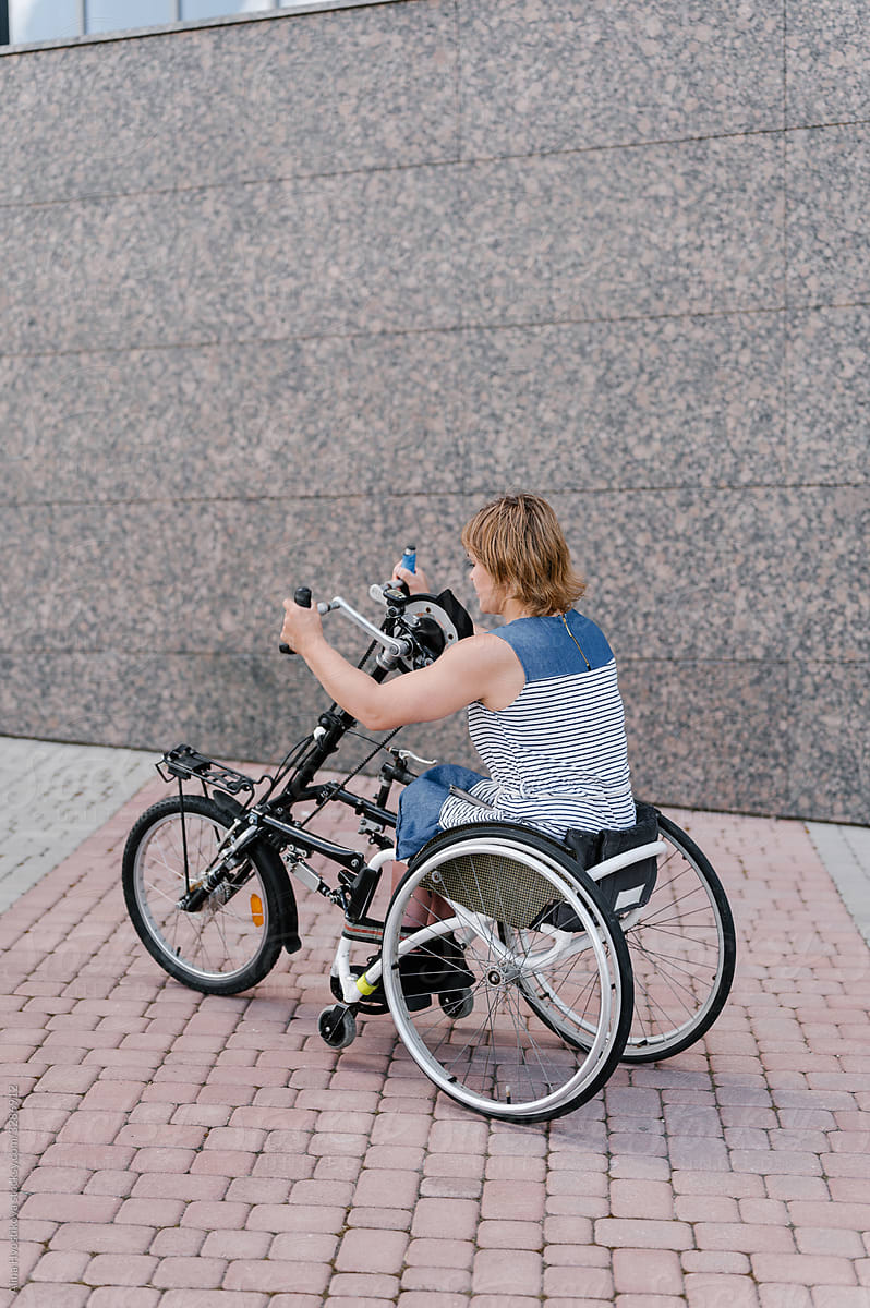 Woman with special needs riding tricycle with manual control