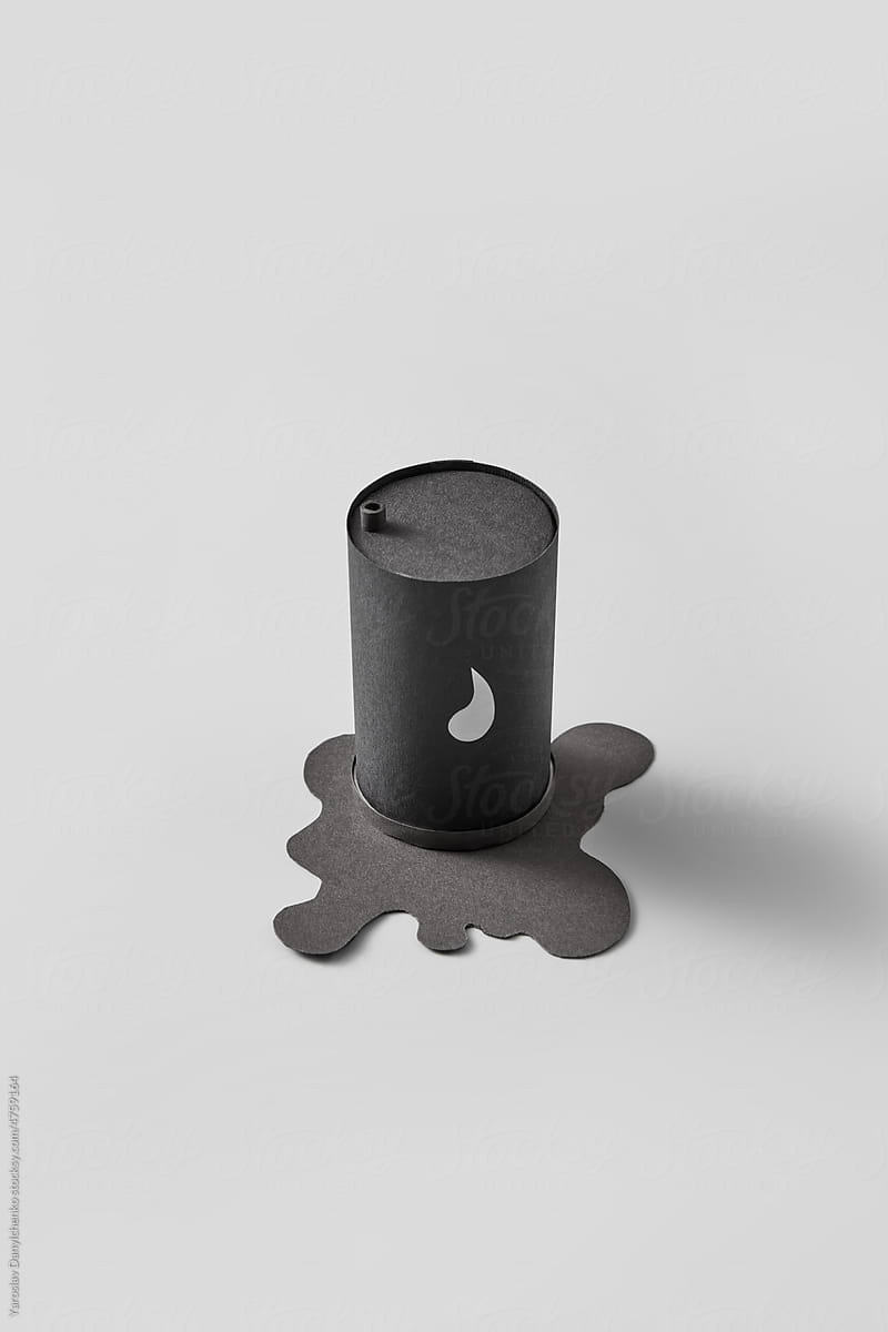 Black barrel with puddle of crude oil.