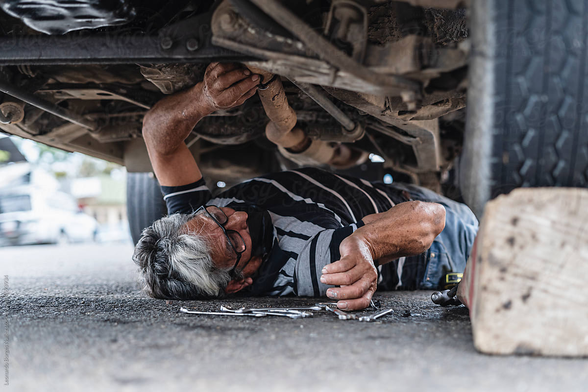 Man mechanic under a car repairing