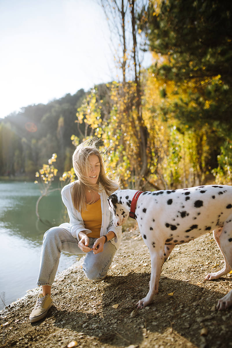 Beautiful woman with her dog during warm autumn sunset