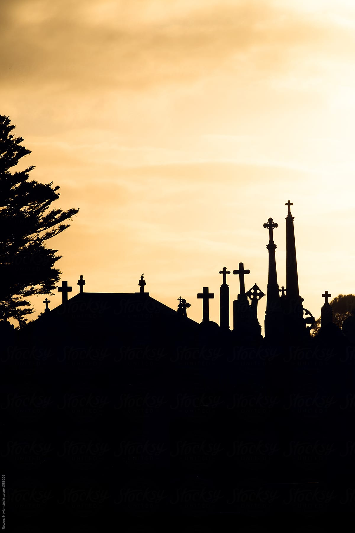 Silouette of catholic gravestones in cemetery
