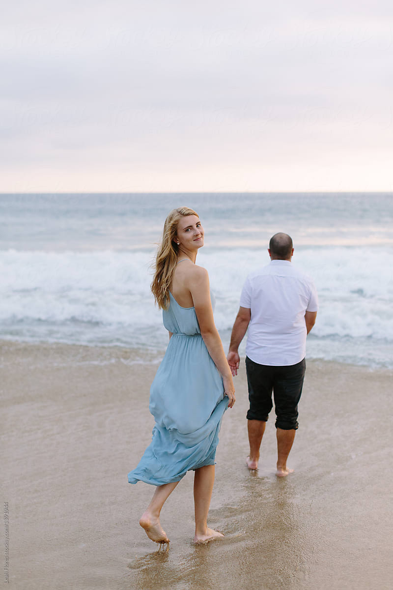 Blonde Woman Looking over Shoulder by Man on Beach