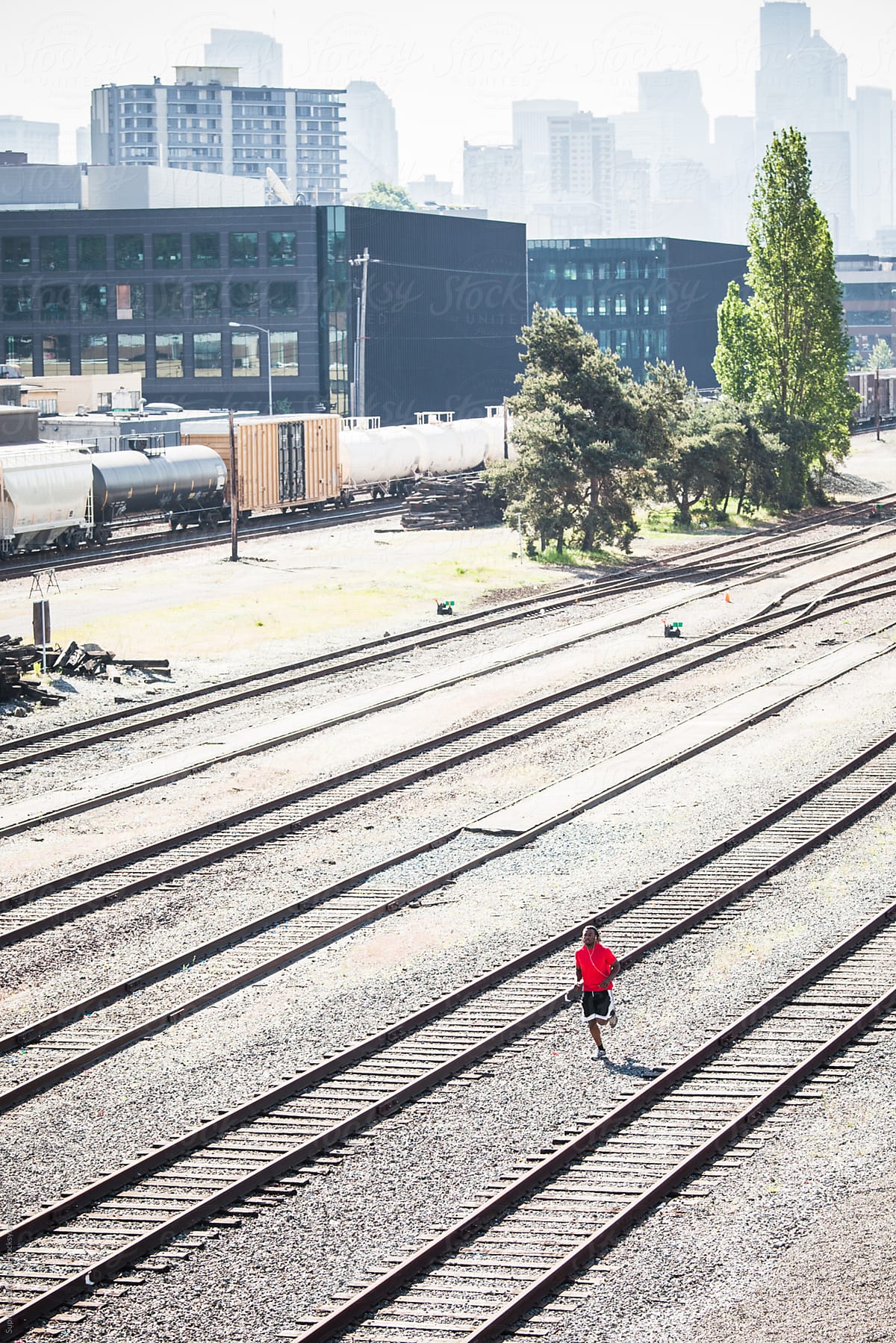 Male athlete running in an urban area next to railroads