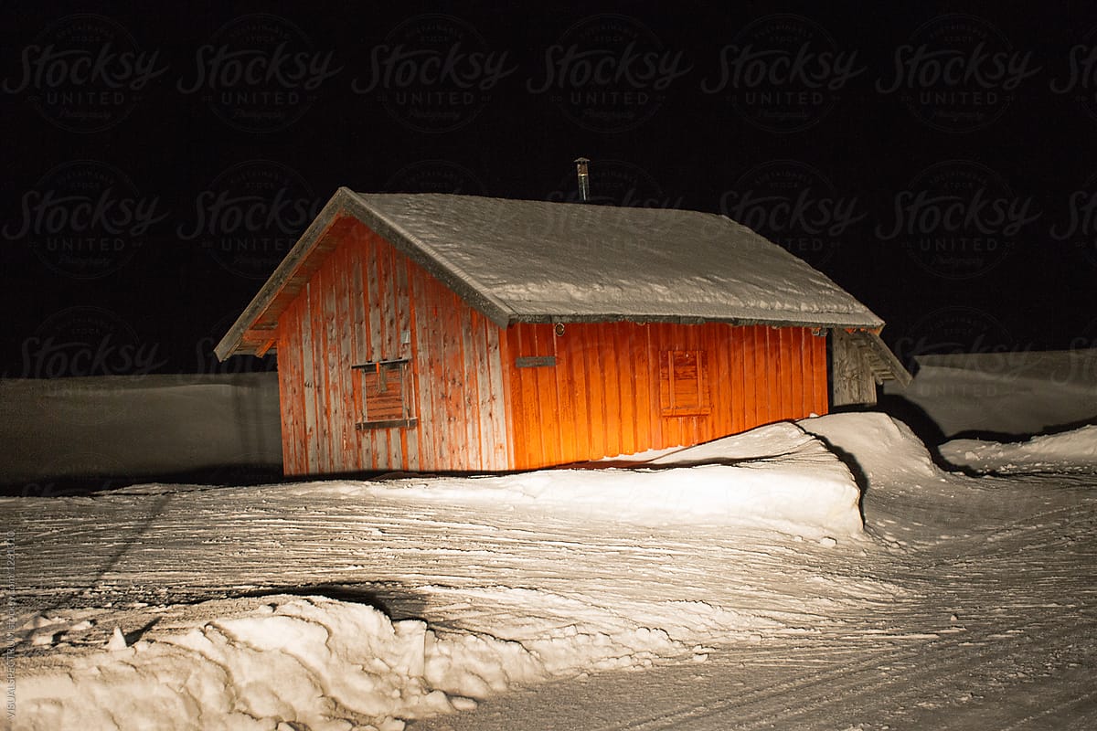 Wintertime - Red Nordic Wood Cabin Illuminated by Car Headlamps