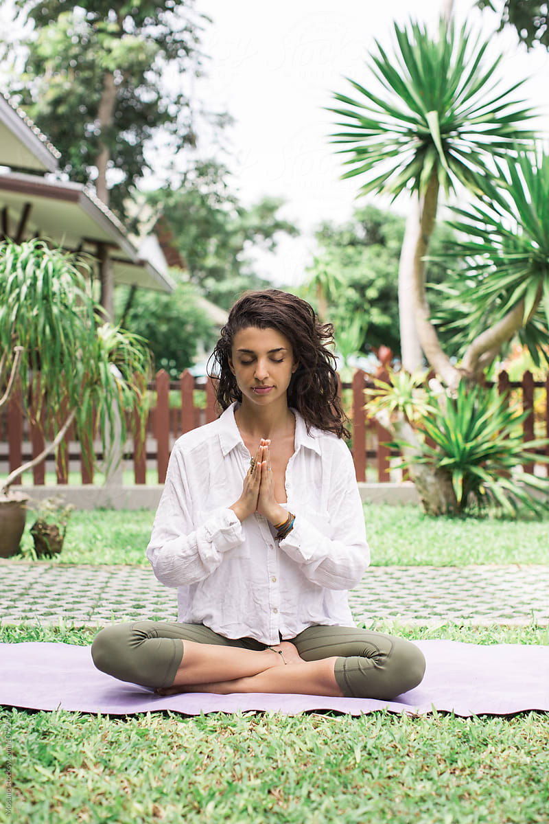 Young Woman Doing Yoga In Meditation Garden by Stocksy