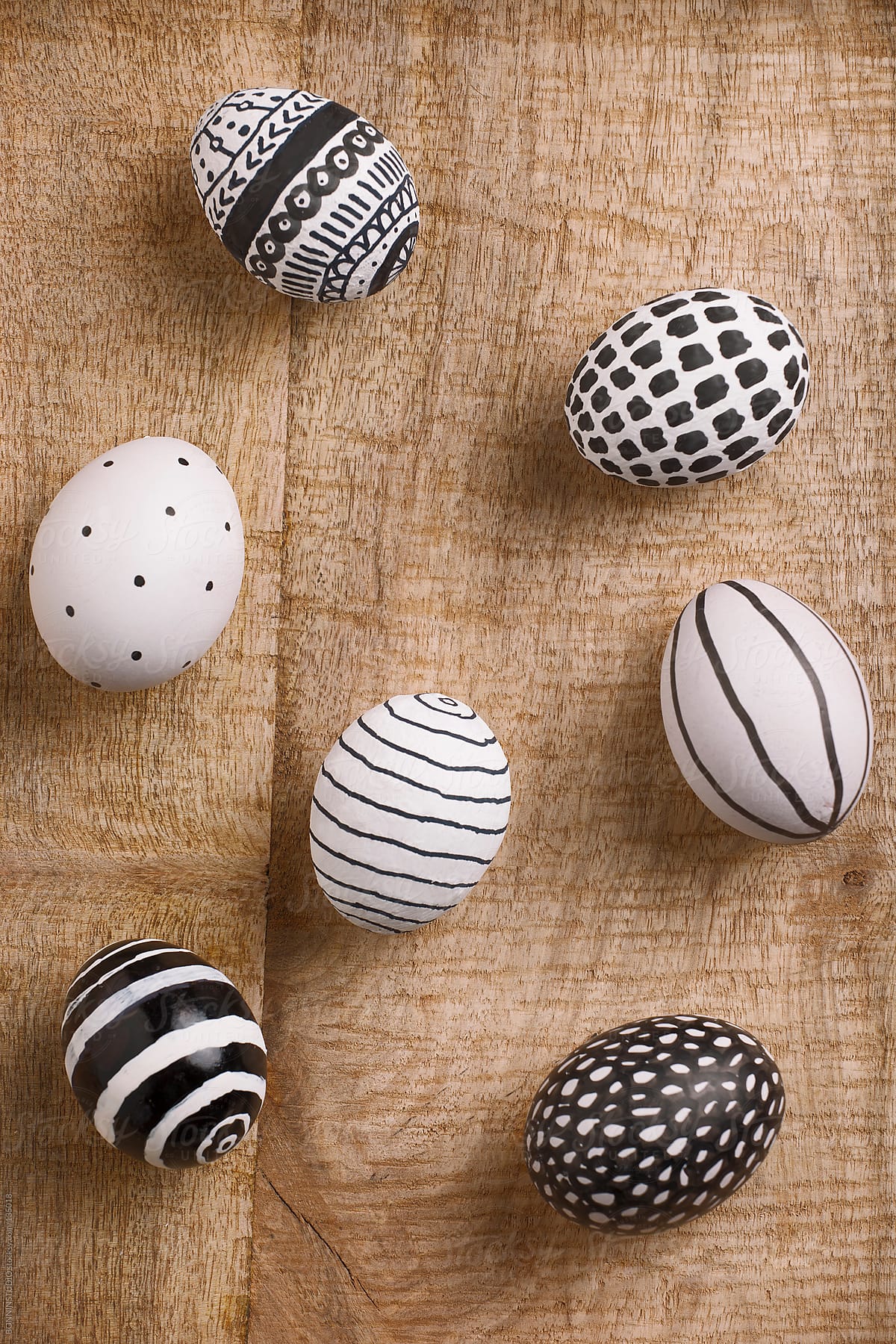 Easter eggs with different drawings on a wood background.