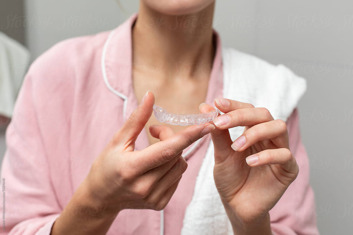 Dental retainer in hands of woman, no face