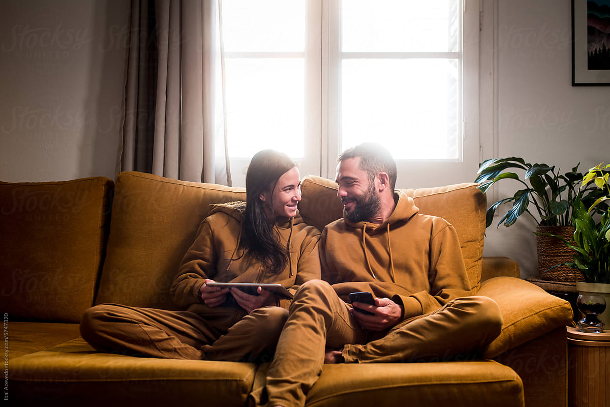 Lazy couple having fun shopping online on the sofa