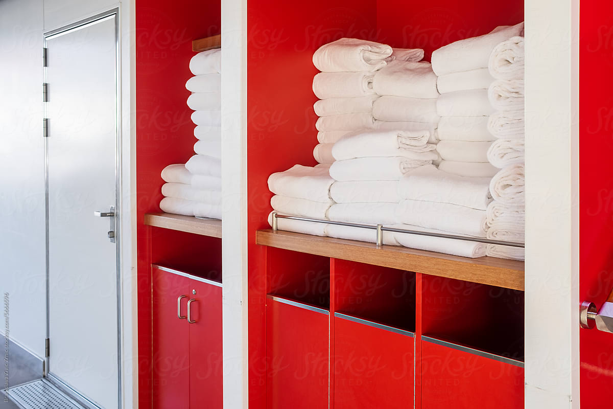 White towels arranged on a red shelf