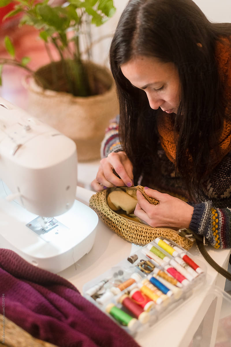 Woman fixing custom handbag sewing at home