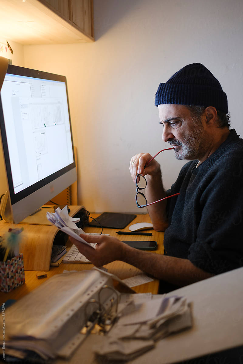 Man organizing receipts for his business tax report in home office