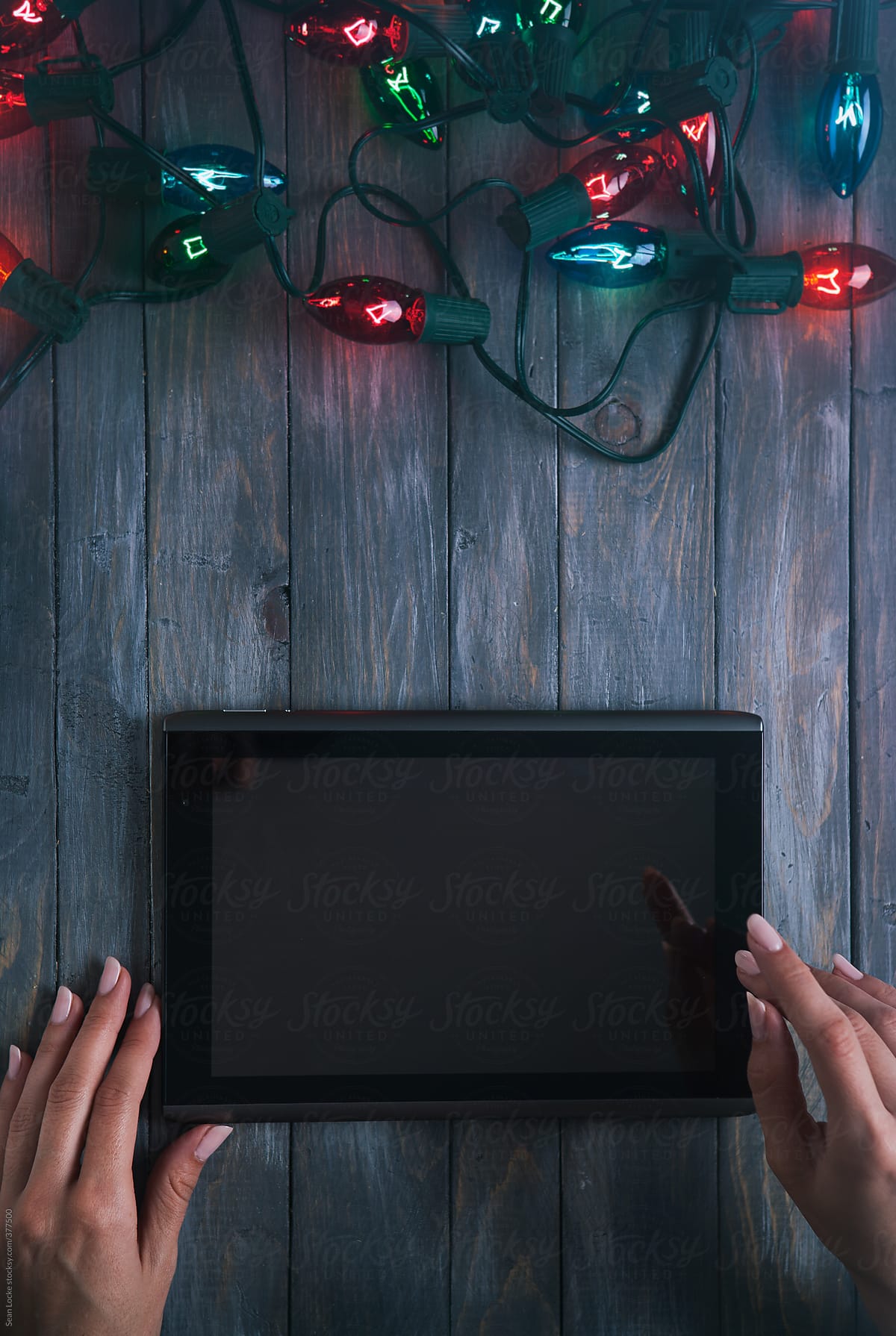 Christmas: Woman Holding Digital Tablet With Christmas Lights At Top