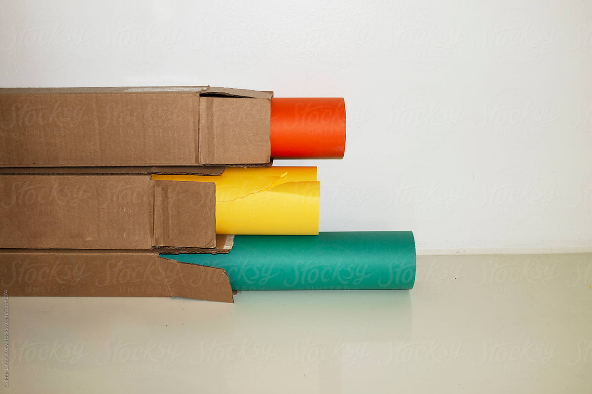 Colourful paper rolls / tubes inside iin brown cardboard boxes