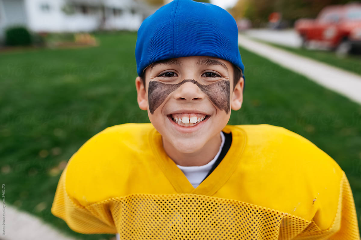 Close up photo of a boy pretending to be a football player.