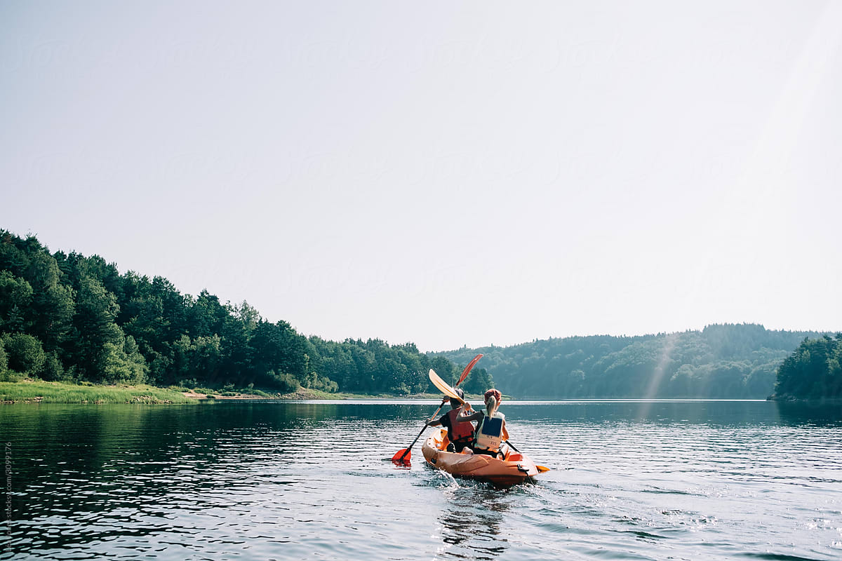 two kids kayaking on a remote lake