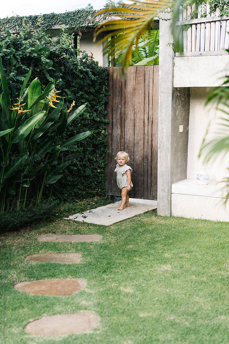 Little kid walking in yard of country house