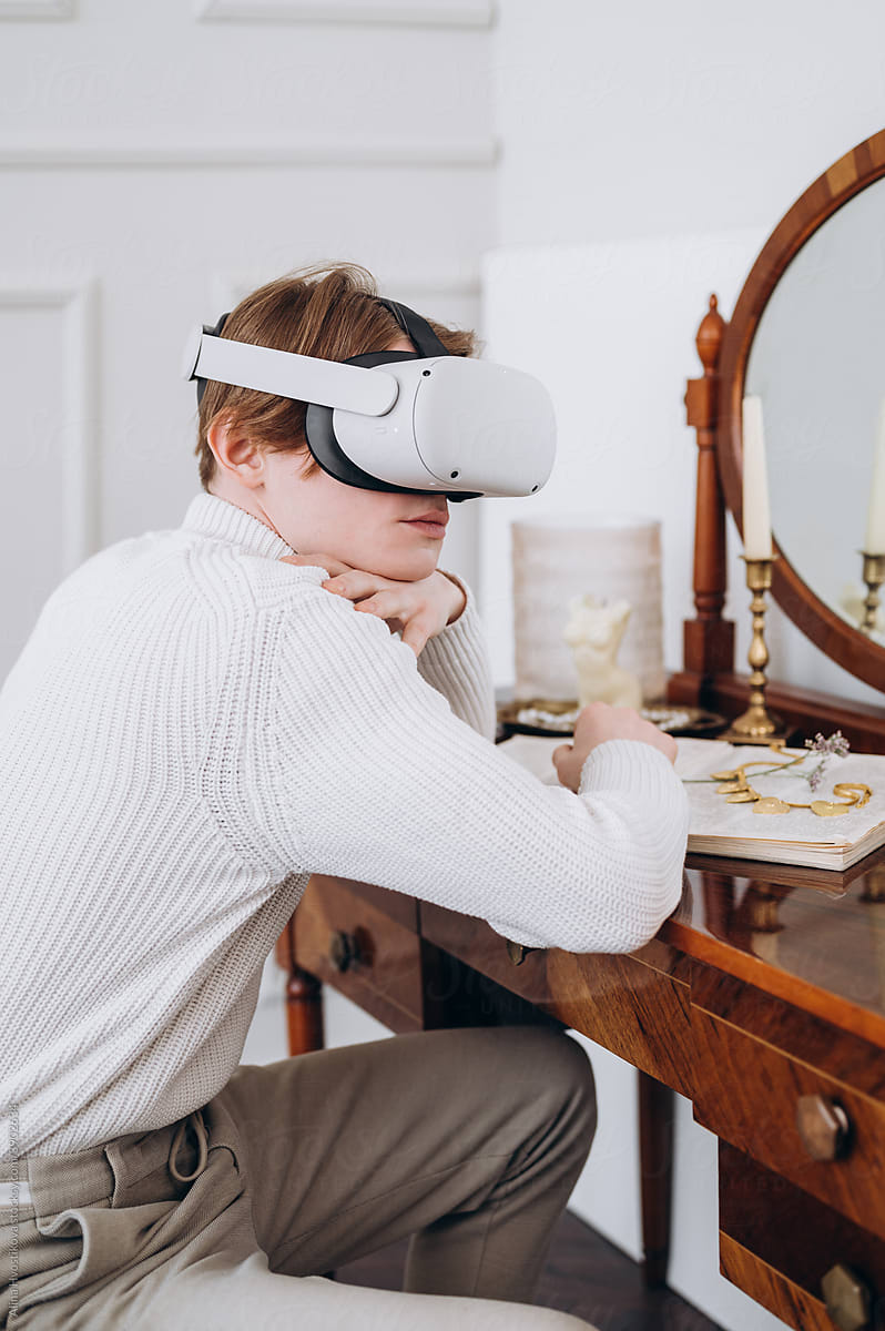 Young man in VR headset sitting at table