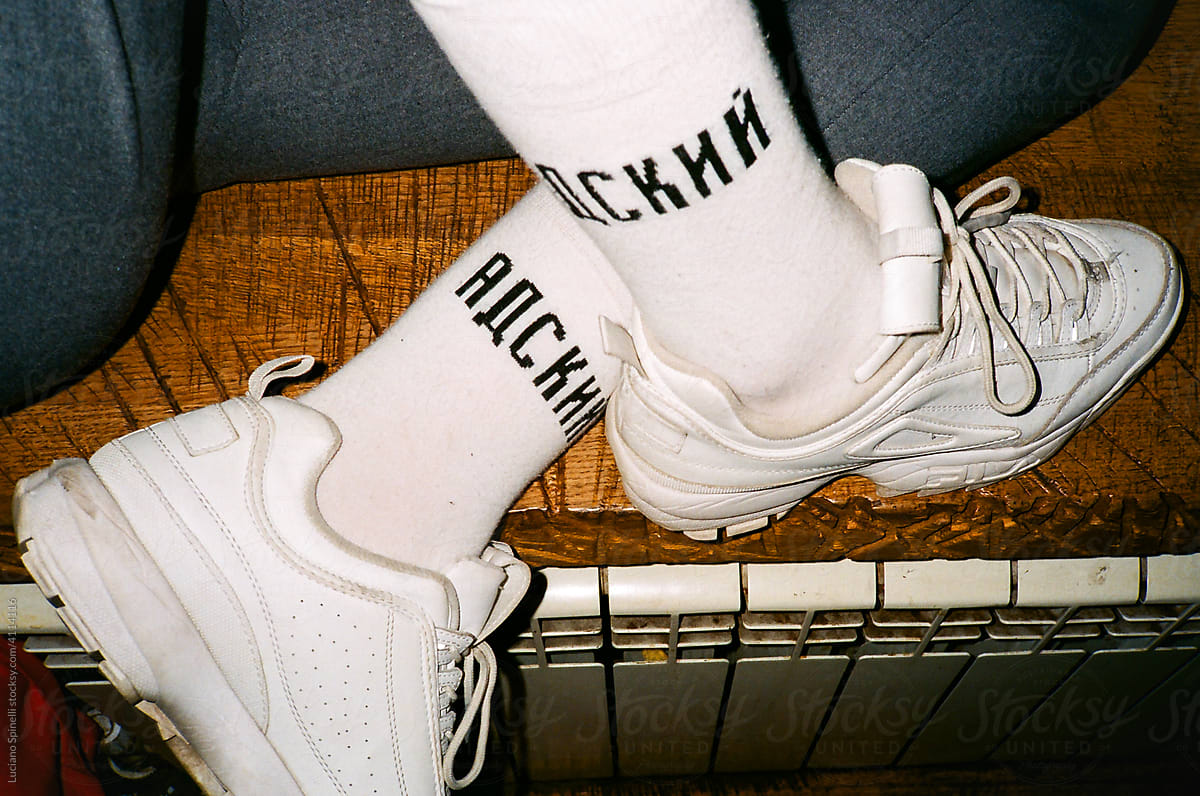 White sneakers and socks of a sited person