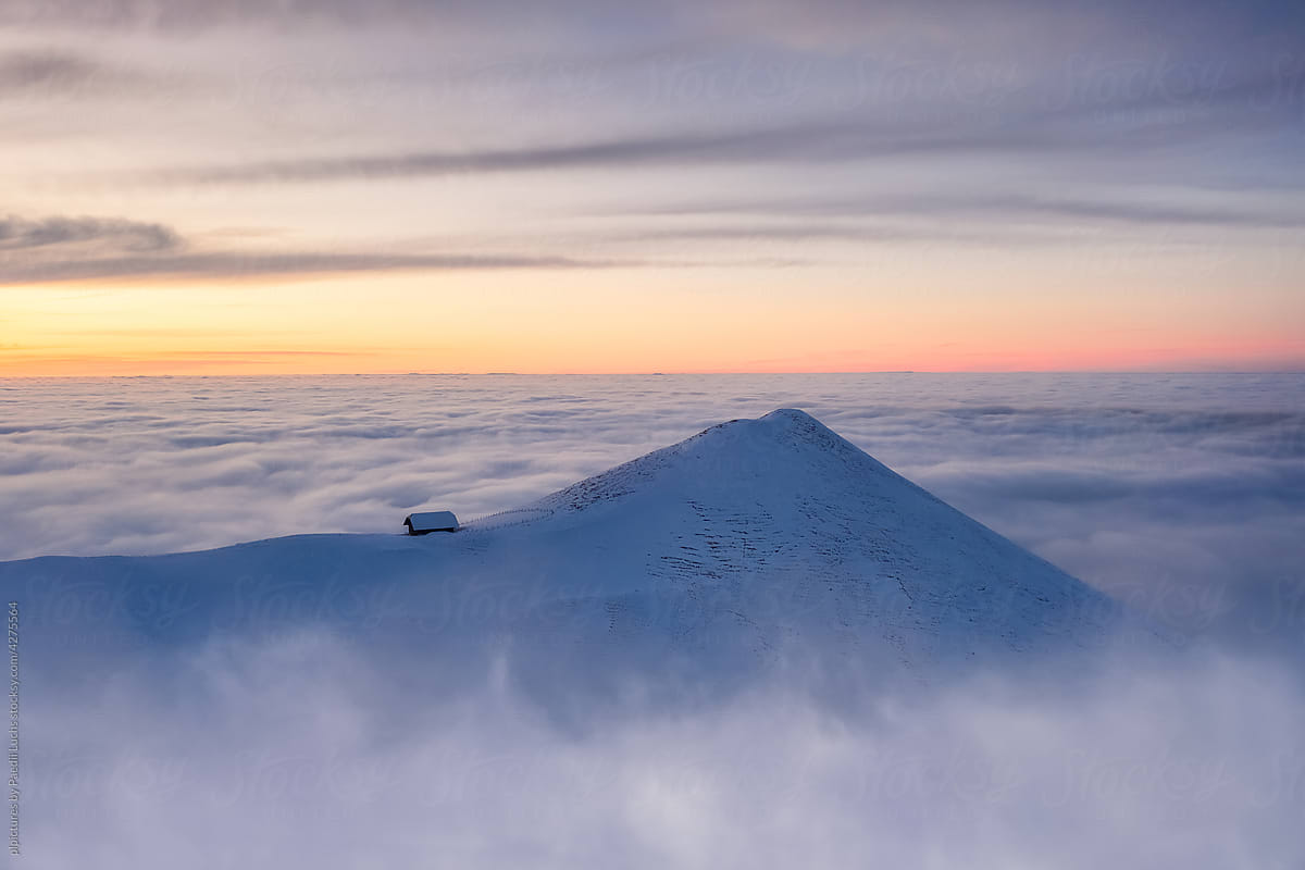 Alpine hut on hill surrounded by fog