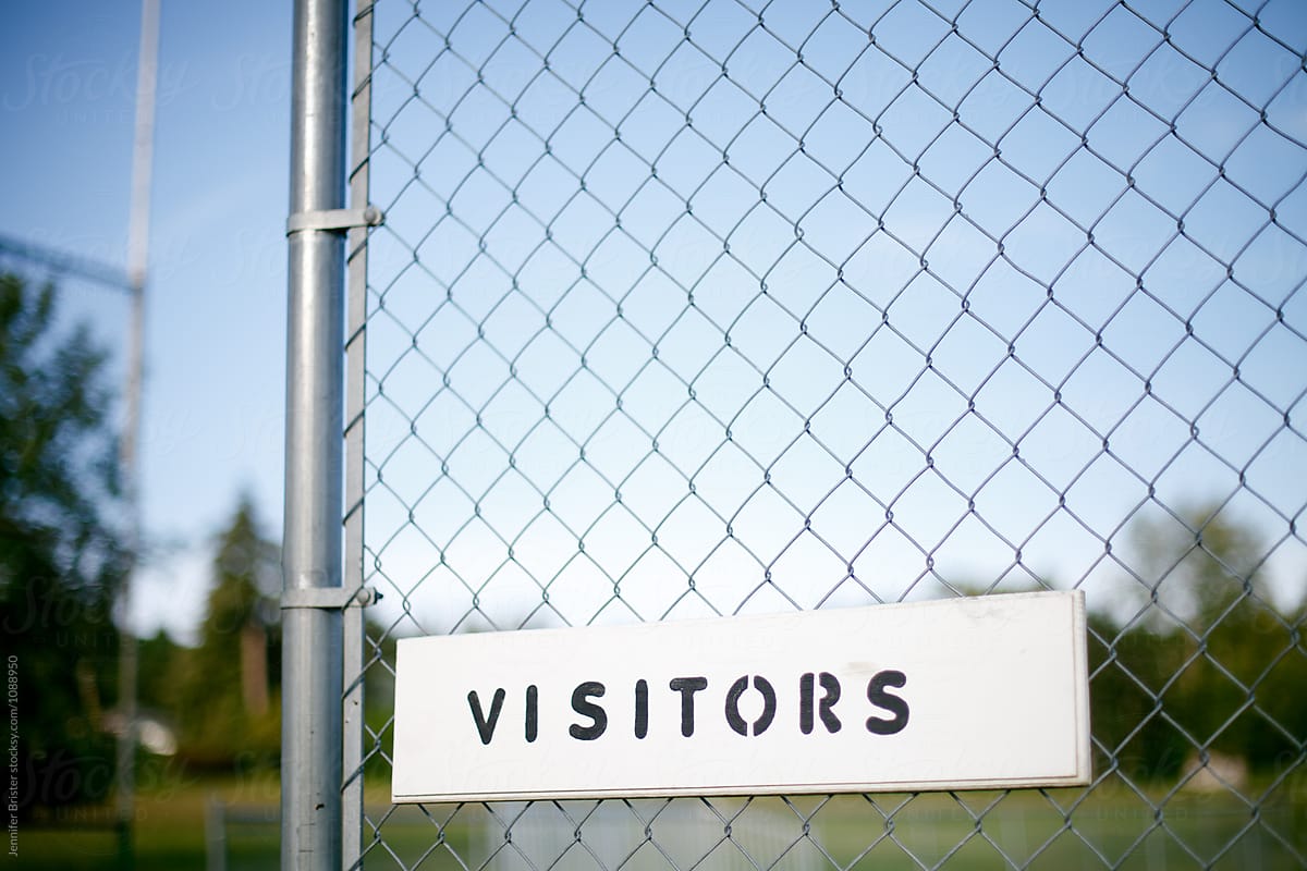 visitors sign on chain link fence to baseball field