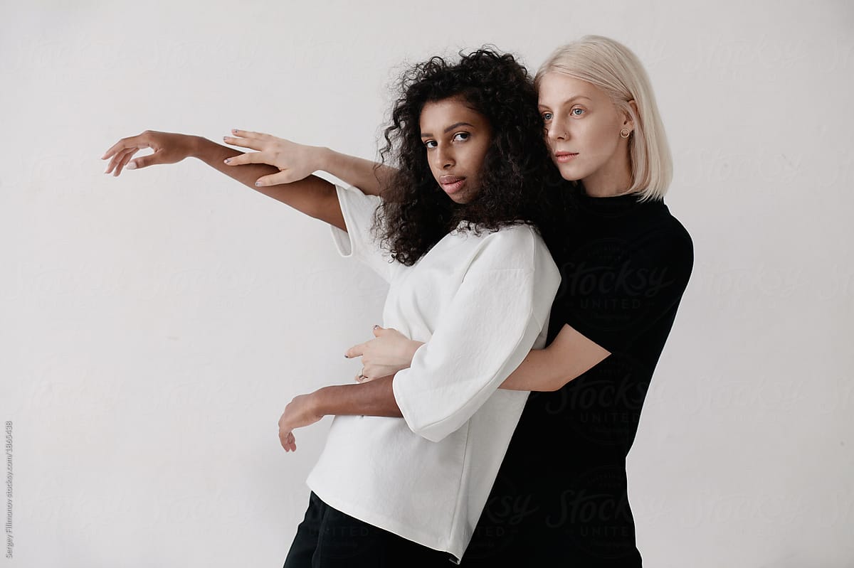 Portrait of two fashionable women in white studio