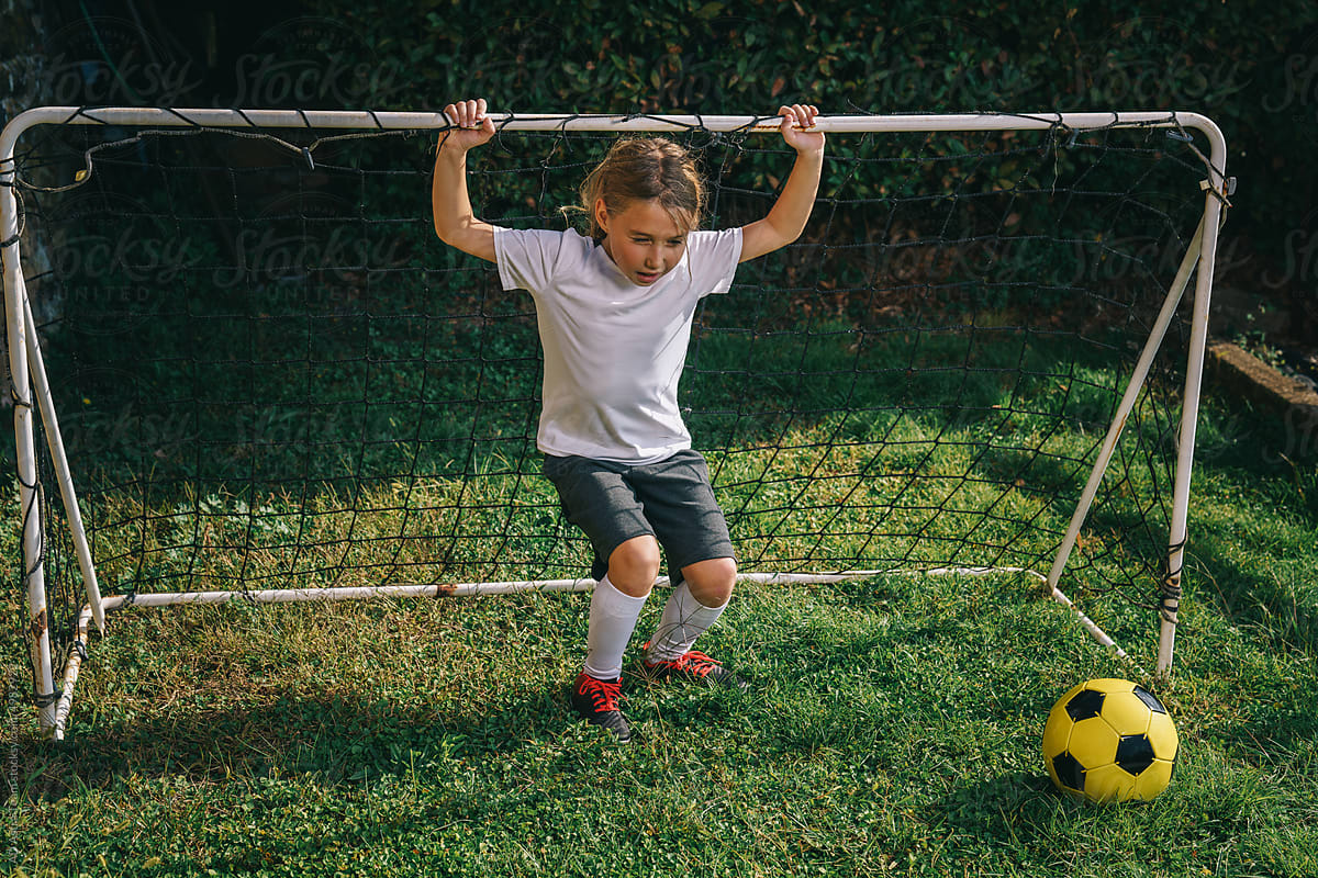 Girl spinning around with a soccer goal