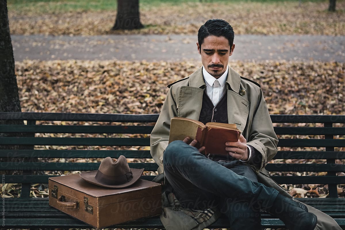 Old Fashioned Man on a Bench Reading a Book