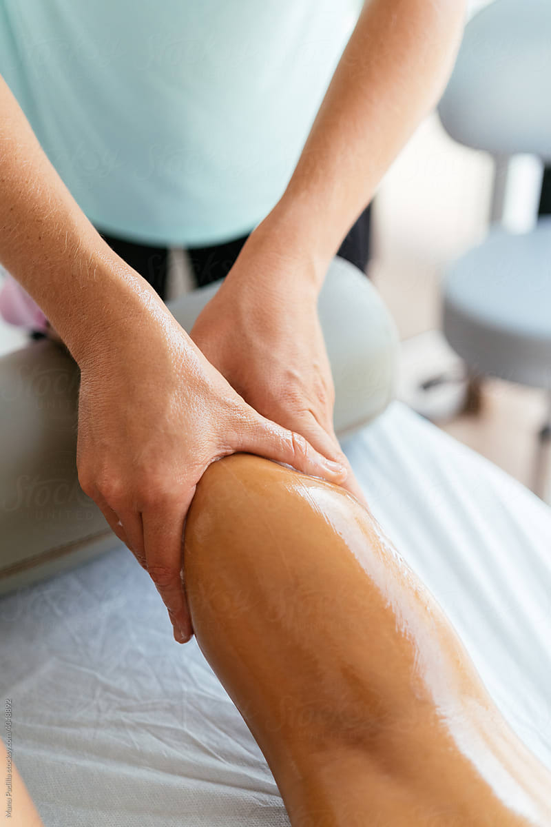Masseuse treating leg of client