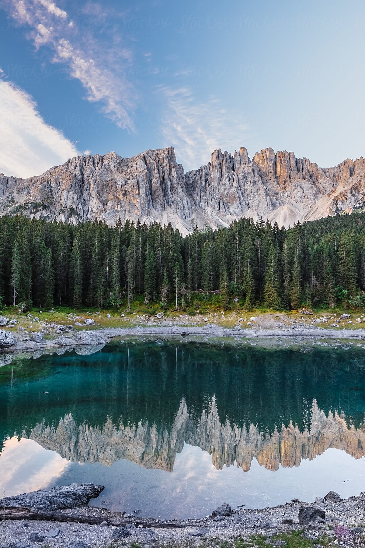 An italian mountain crystal clear lake with mountains at the background and still calm bank at the front