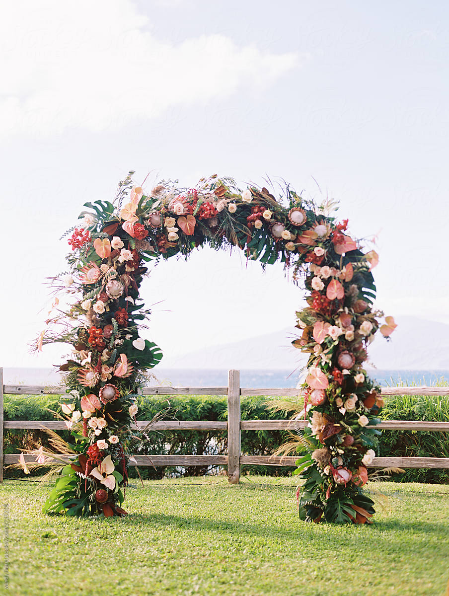 Flowered wedding arch on cliff over ocean