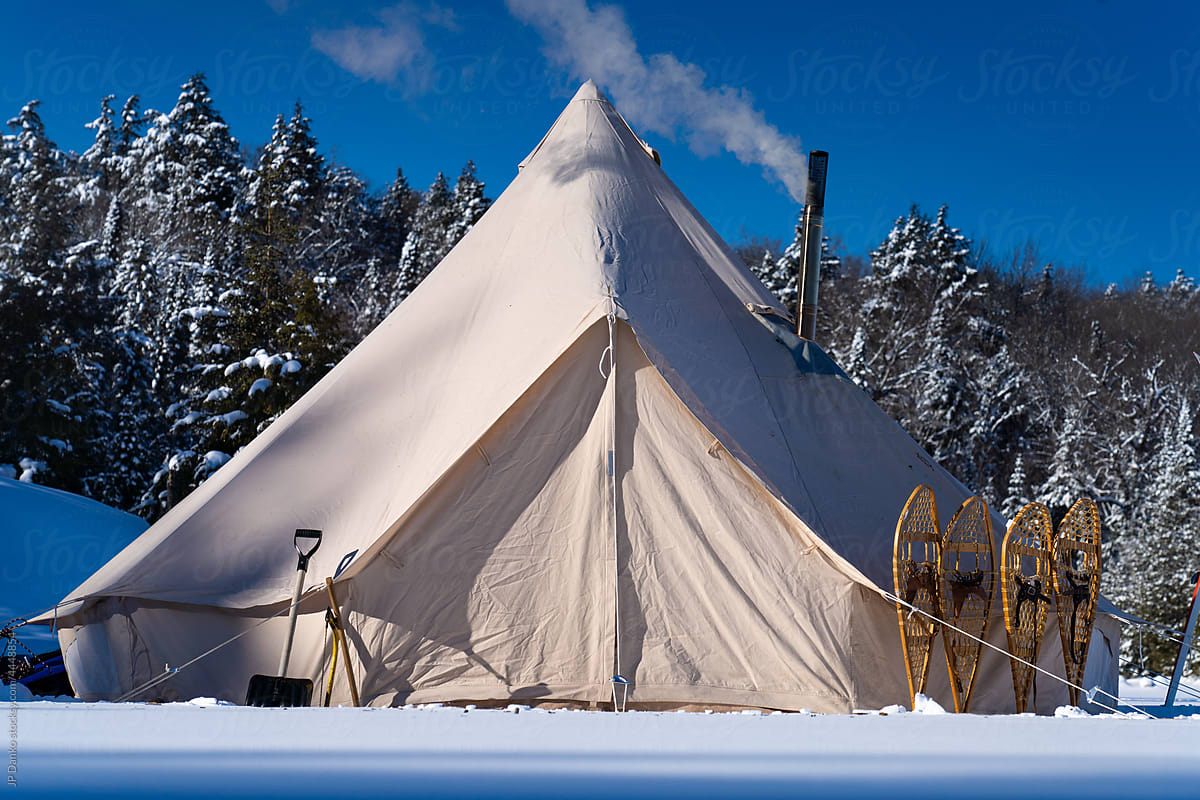 Traditional Canvas Tent and Snowshoes in Winter Landscape