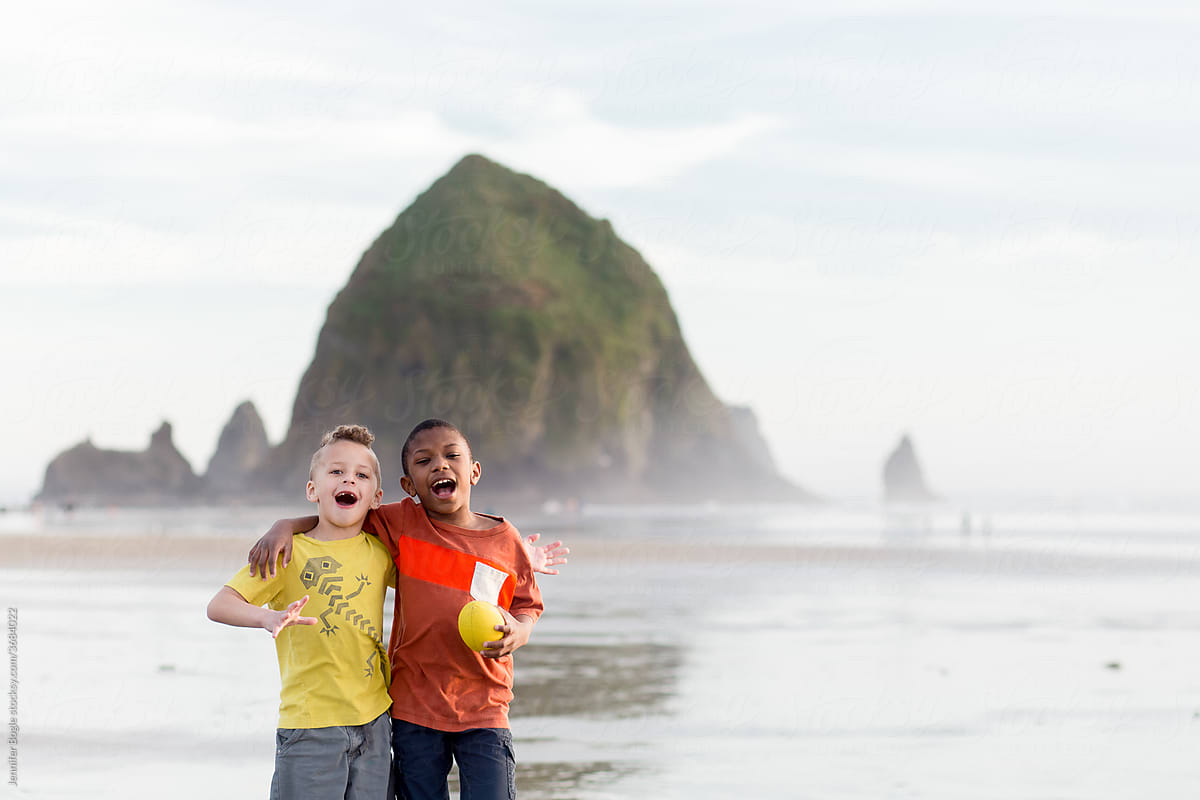 Brothers shout and hug on Cannon Beach
