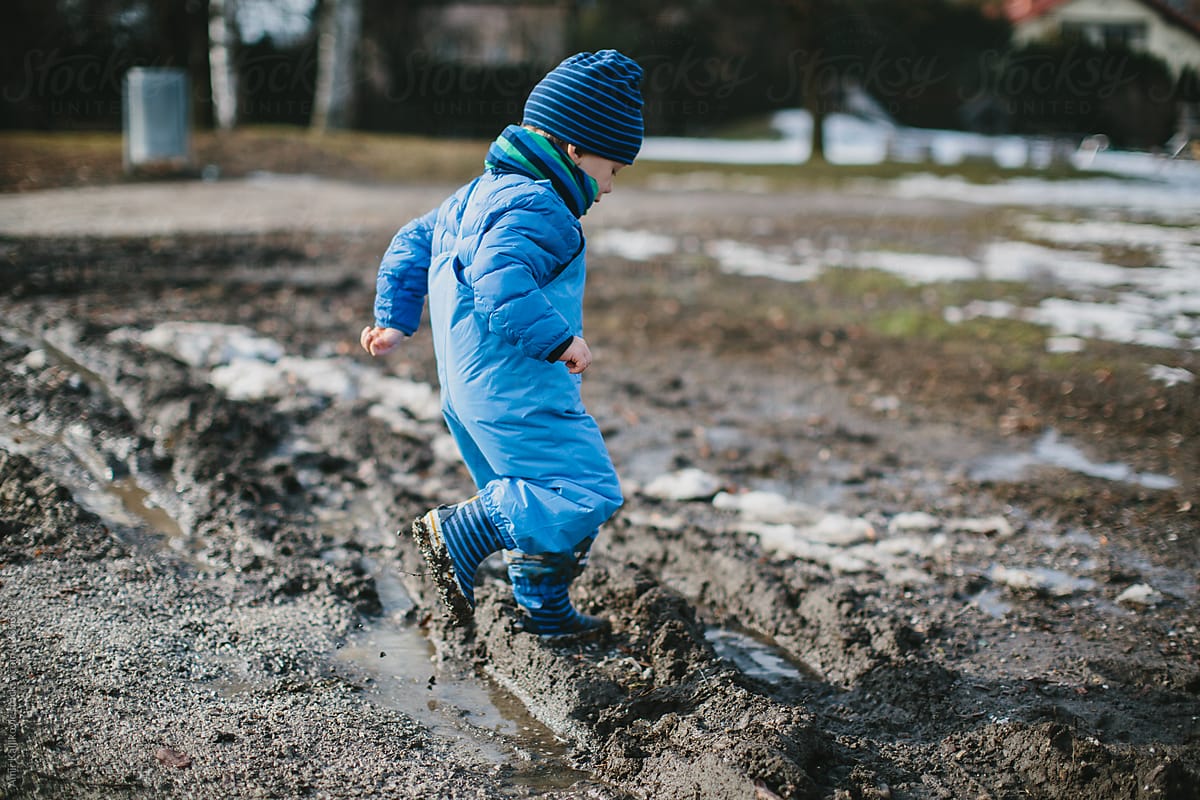 Boy jumping in the mud