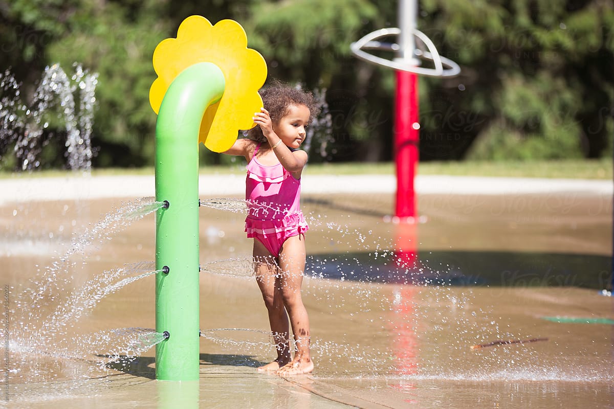 A child playing happily in the water at a splash pad