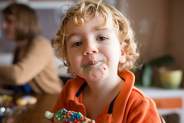 Boy Reads On Couch In Front Of Rainbow Streamers by Stocksy Contributor  Jennifer Bogle - Stocksy