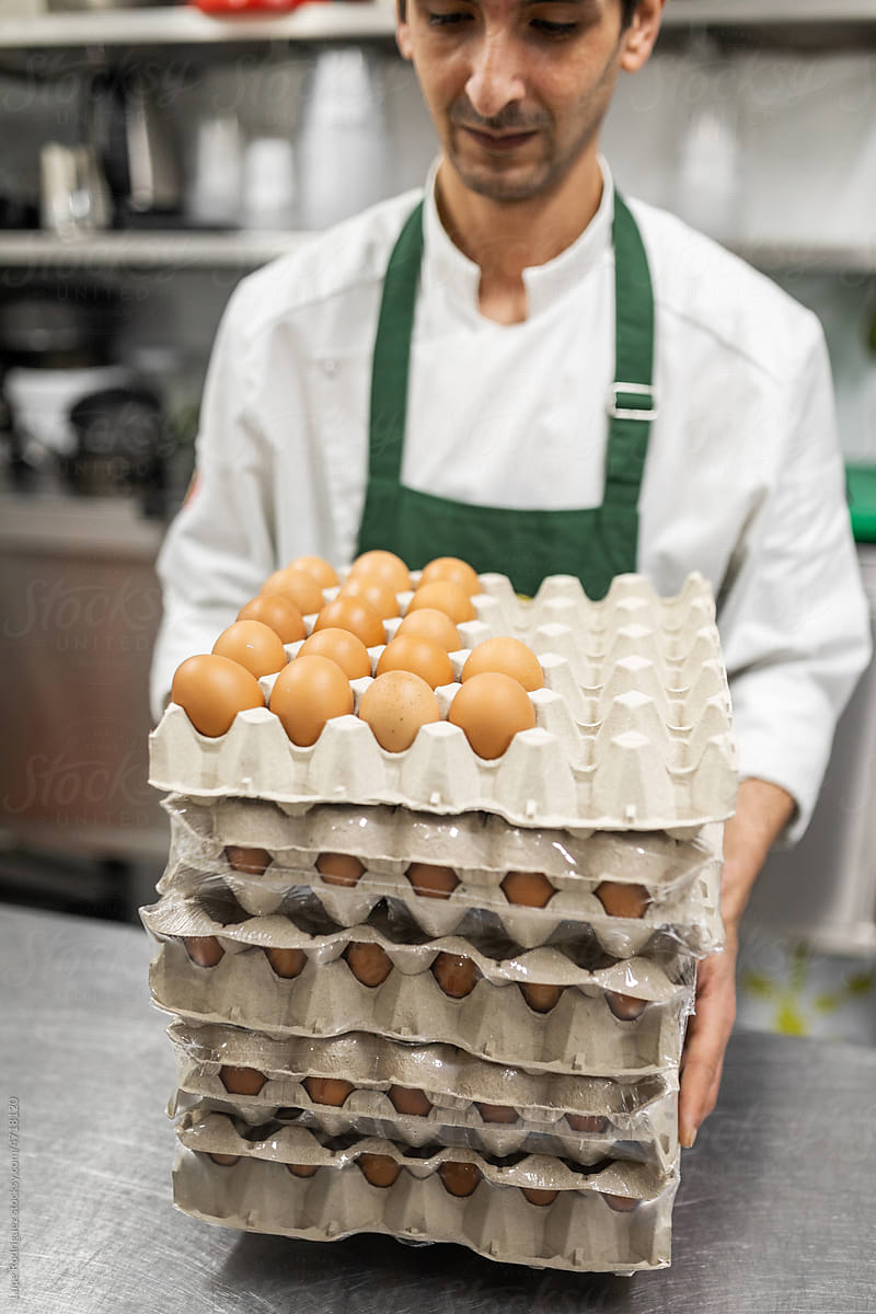 chef carrying eggs in a kitchen