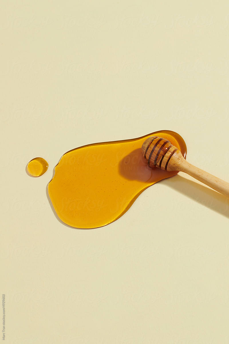 Sweet honey and dipper on light yellow background