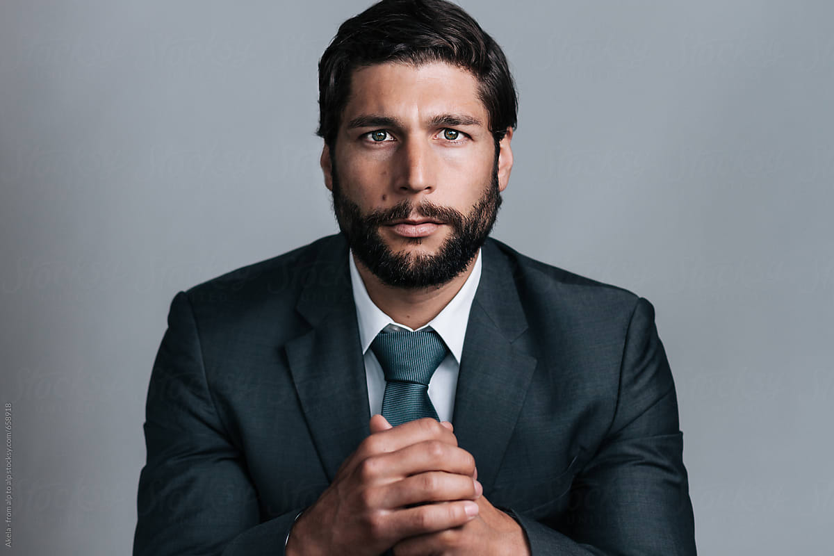 studio portrait of full bearded well dressed young business man looking in the camera